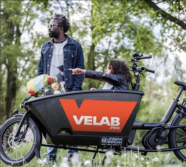 Une famille à vélo dans une ville européenne — père avec enfant sur porte-bagage, balade urbaine